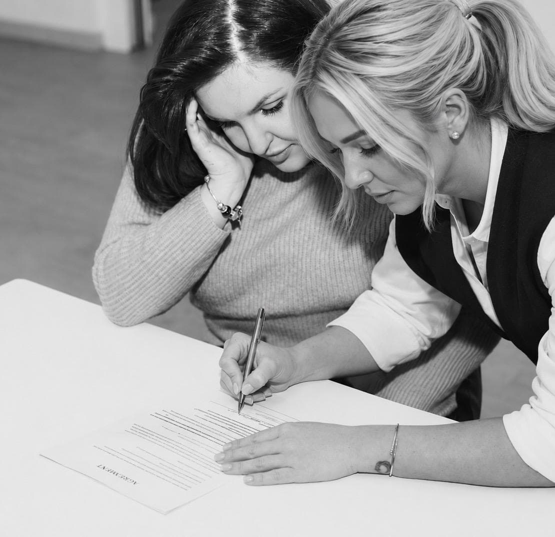 A student signing her training agreement at the academy